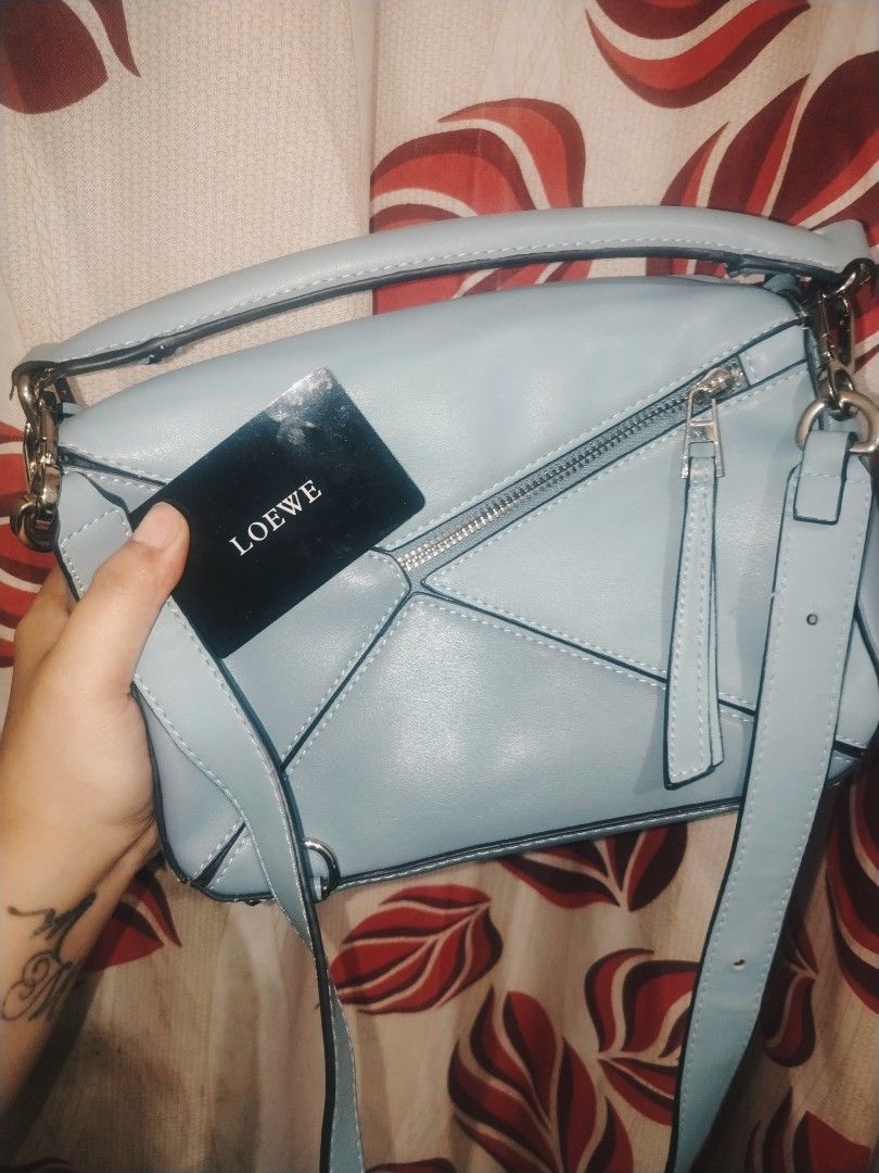 Loewe Puzzle Bag Light Blue (Category: Luxury Bags & Wallets) located in Manila. Submitted by warmwater.788864 (Listing ID 1468784994, Image 1). Description: - Authentic Loewe Puzzle Bag in a gorgeous light blue shade - Iconic geometric panel design with top handle and removable shoulder strap - Silver-tone hardware complete with branded clasps and zip pulls - Luxurious beige herringbone fabric lining with embossed 'Made in Spain' leather tag - I