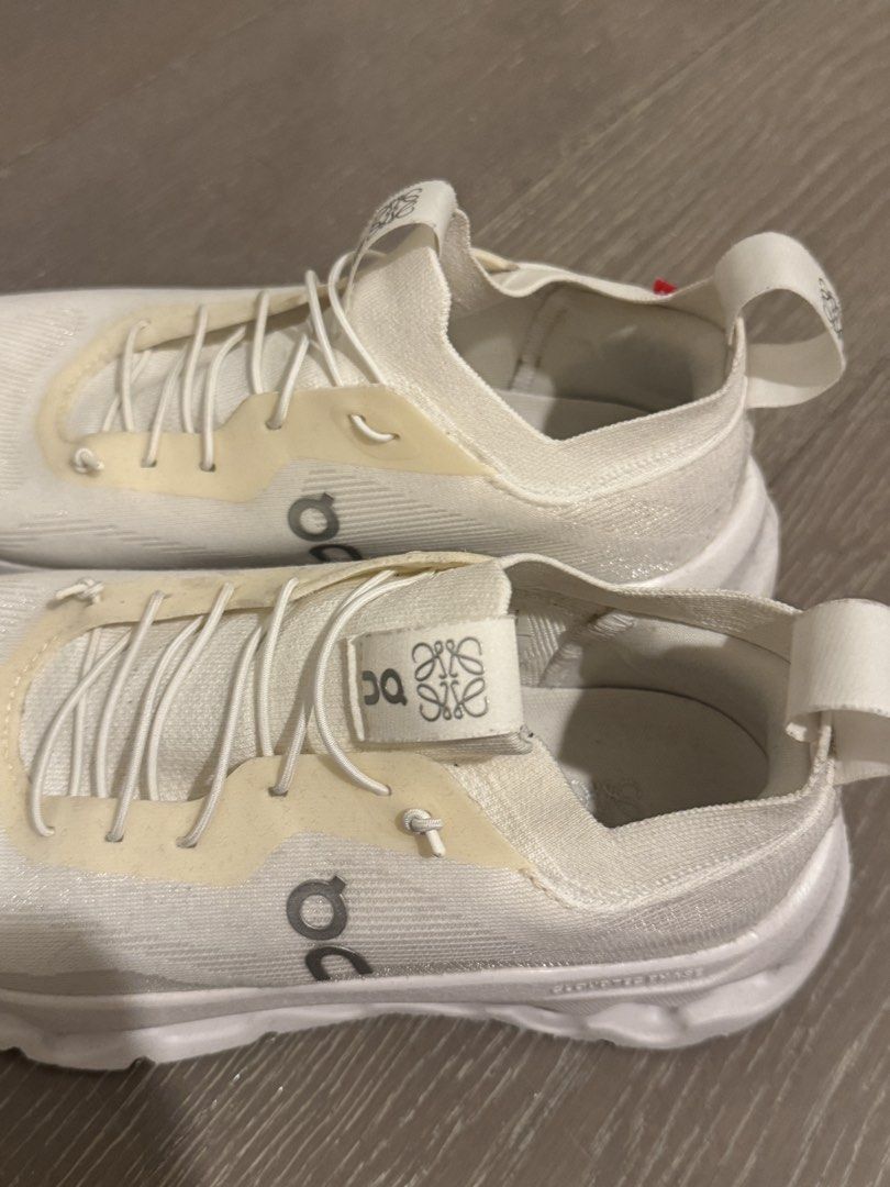 Loewe x On Cloudtilt Phase Sneakers White (Category: Sneakers) located in Pasig City. Submitted by furniture.decultter (Listing ID 1468849288, Image 2). Description: - Item: Loewe x On Cloudtilt Phase Sneakers - Color: Clean White - Size: US W 8.5 / UK 6.5 / EU 40 / JP 25.5 - Features: Lightweight knit upper, chunky CloudTec Phase sole, slip-on collar with speed lacing - Branding: Iconic Loewe anagram on the side and tongue tab - Vibe: Super comf