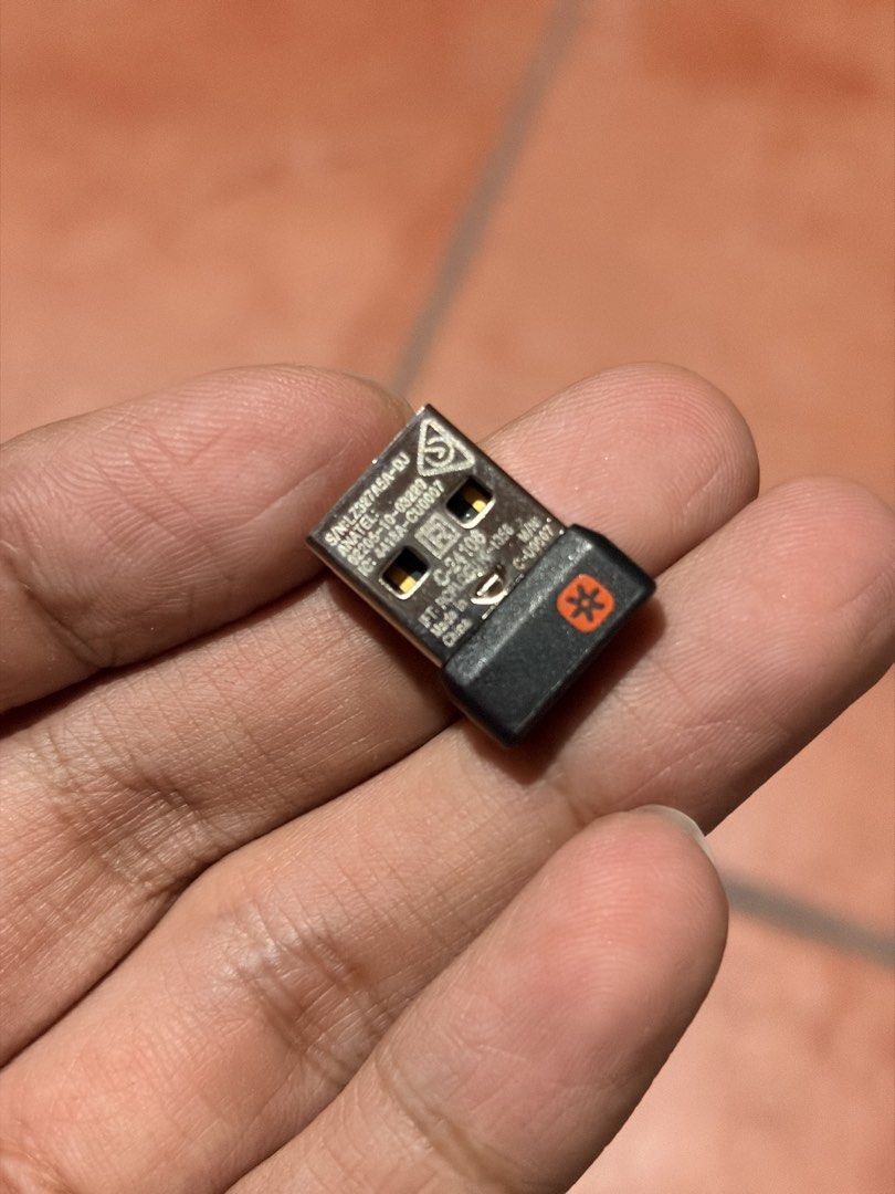 Logitech Unifying USB Receiver (Category: Cables & Adaptors) located in Manila. Submitted by knightto2112 (Listing ID 1468863375, Image 3). Description: - Authentic Logitech Unifying USB receiver with the iconic orange asterisk logo - Model: C-U0007 (S/N LZ327A5A-DJ) - Ideal replacement for lost or broken wireless dongles - Compatible with various Logitech mice and keyboards that support the Unifying protocol - Plug-and-play ready and works perfe
