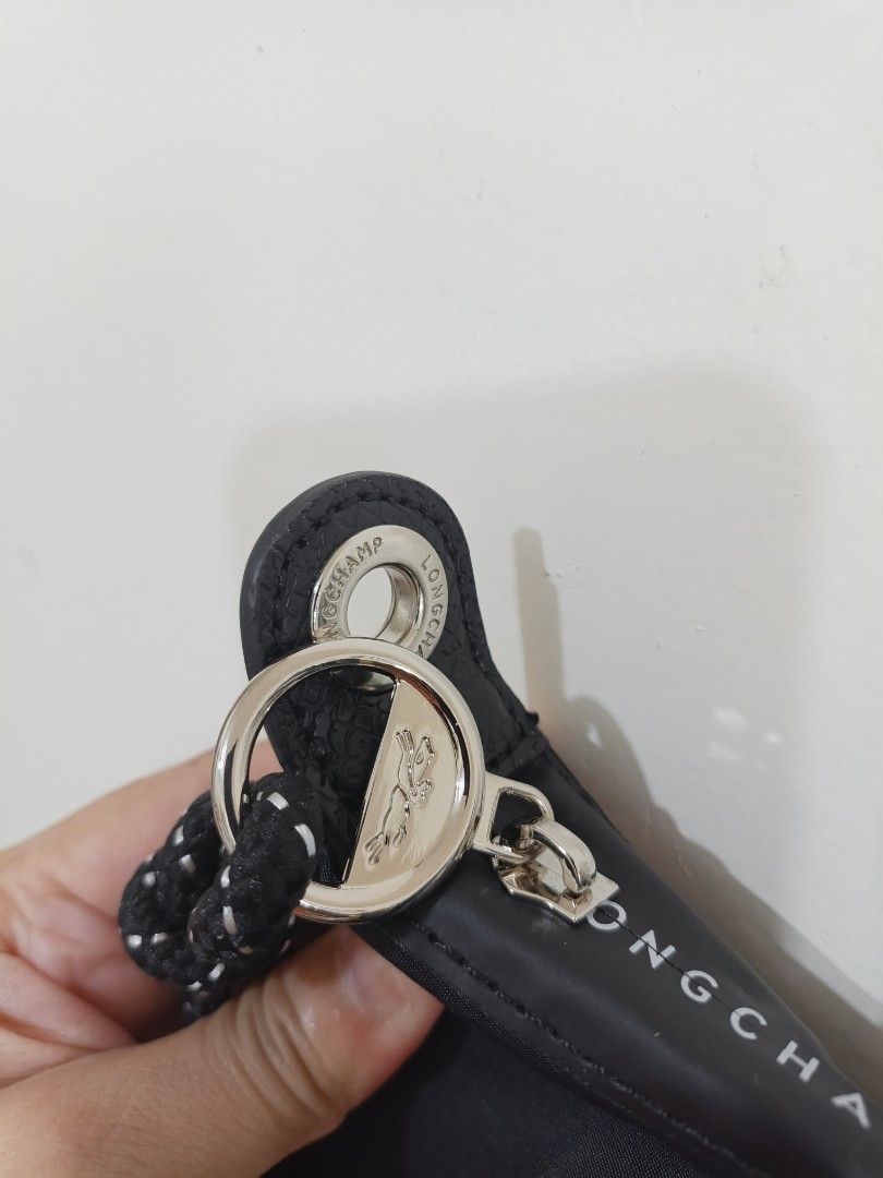 Longchamp Black Nylon Handbag with sling (Category: Luxury Bags & Wallets) located in Quezon City. Submitted by closeta38 (Listing ID 1468725058, Image 3). Description: - Brand: Longchamp - Material: Durable black nylon with genuine leather flap and handles - Condition: Brand new, handles still wrapped in original plastic - Hardware: Silver-tone with iconic horse logo snap button - Features: Lightweight, minimalist design with a spacious interior