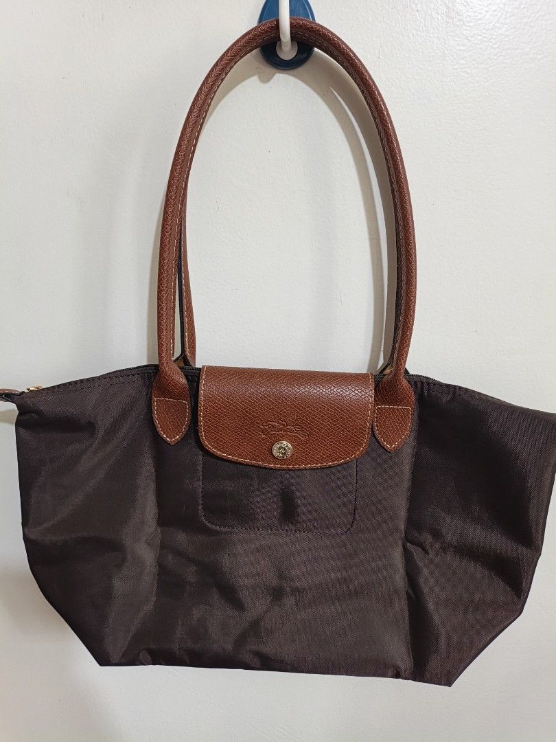 Longchamp Brown Tote Bag (Category: Luxury Bags & Wallets) located in Quezon City. Submitted by closeta38 (Listing ID 1468727198, Image 1). Description: - Authentic brown Longchamp tote bag - Durable nylon body with classic brown leather handles and flap closure - Elegant gold-tone hardware with signature horse logo details - Double shoulder strap design for comfortable carrying - Clean interior and exterior, ready for daily use - Spacious size, 