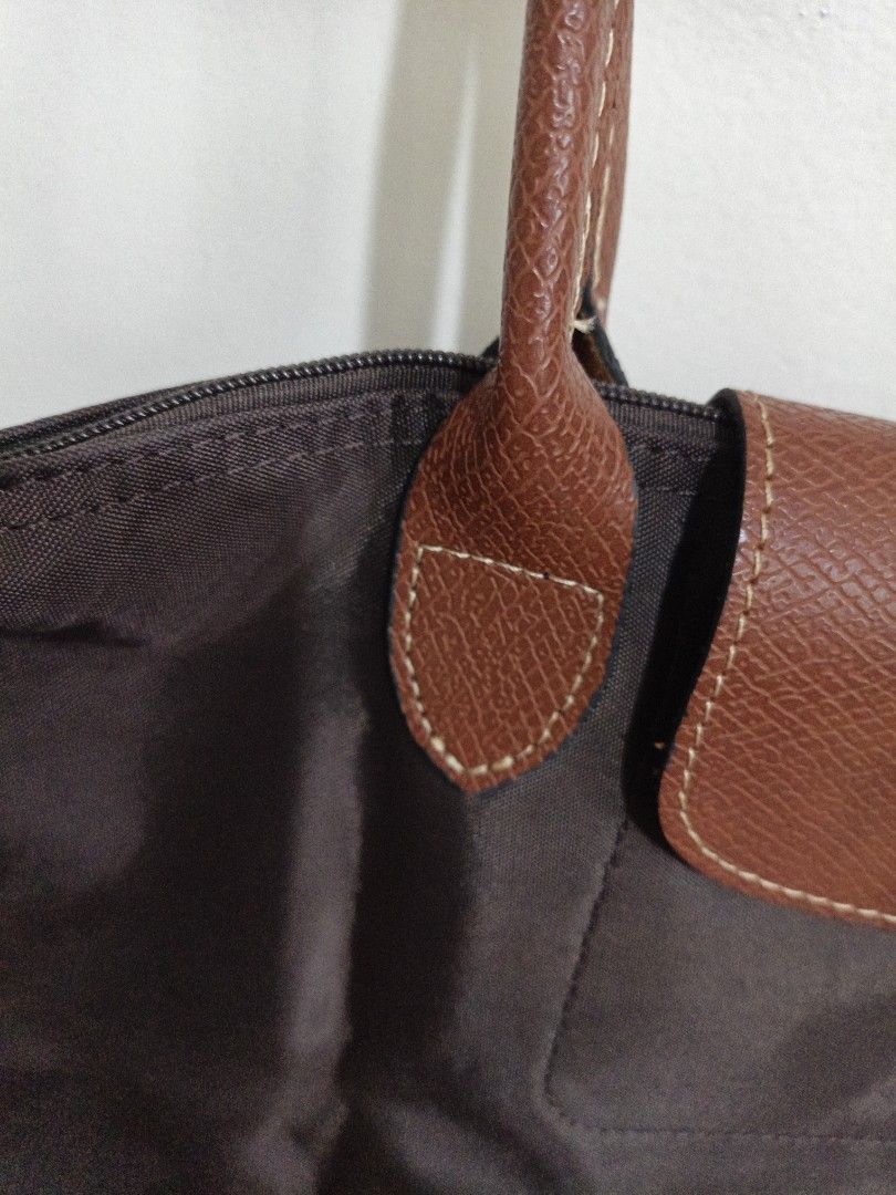Longchamp Brown Tote Bag (Category: Luxury Bags & Wallets) located in Quezon City. Submitted by closeta38 (Listing ID 1468727198, Image 3). Description: - Authentic brown Longchamp tote bag - Durable nylon body with classic brown leather handles and flap closure - Elegant gold-tone hardware with signature horse logo details - Double shoulder strap design for comfortable carrying - Clean interior and exterior, ready for daily use - Spacious size, 