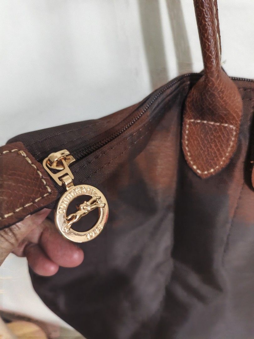 Longchamp Brown Tote Bag (Category: Luxury Bags & Wallets) located in Quezon City. Submitted by closeta38 (Listing ID 1468727198, Image 2). Description: - Authentic brown Longchamp tote bag - Durable nylon body with classic brown leather handles and flap closure - Elegant gold-tone hardware with signature horse logo details - Double shoulder strap design for comfortable carrying - Clean interior and exterior, ready for daily use - Spacious size, 