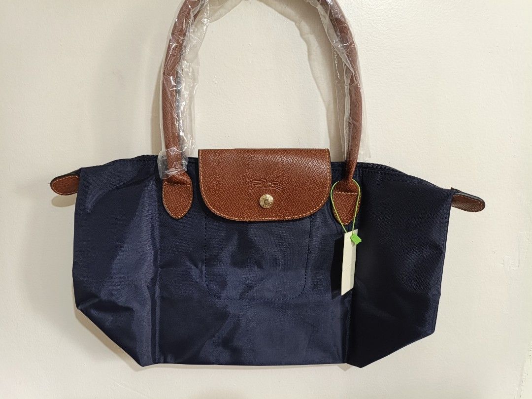 Longchamp Le Pliage Navy Nylon Tote Bag (Category: Luxury Bags & Wallets) located in Quezon City. Submitted by closeta38 (Listing ID 1468724901, Image 1). Description: - Longchamp Le Pliage Tote Bag - Color: Navy blue nylon with brown leather flap and handles - Hardware: Gold-tone with iconic horse logo and 1948 branding - Condition: Brand new, tag attached to side ring, handles still in original plastic packaging - Perfect for daily use, travel,