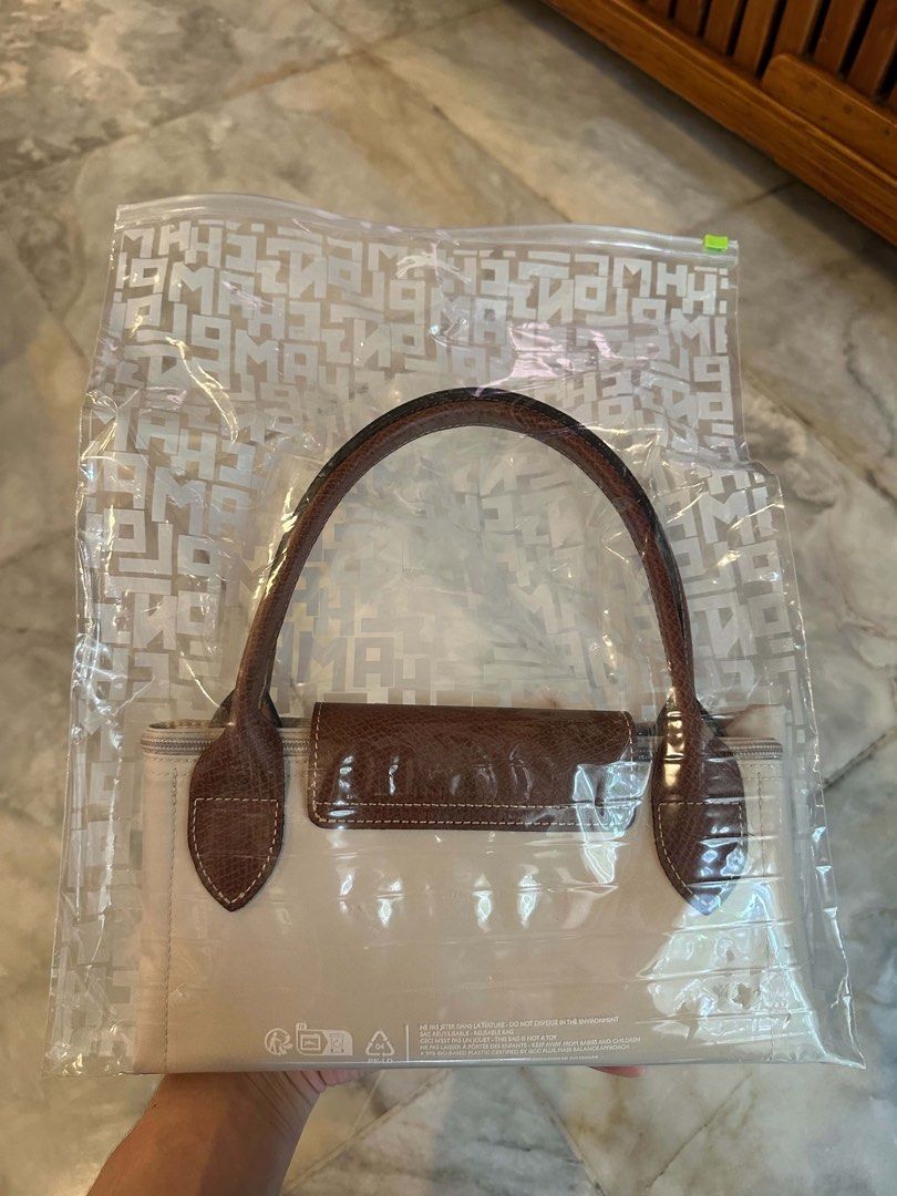 Longchamp Size M (Category: Luxury Bags & Wallets) located in Quezon City. Submitted by sofiedy (Listing ID 1468803928, Image 1). Description: - Bought in Berlin, Germany - 100% Authentic Longchamp branded bag - Brand new and unopened in original protective plastic packaging - Elegant neutral beige canvas body paired with classic brown leather handles and flap closure - Convenient foldable design for easy storage and travel - Secure top zipper cl