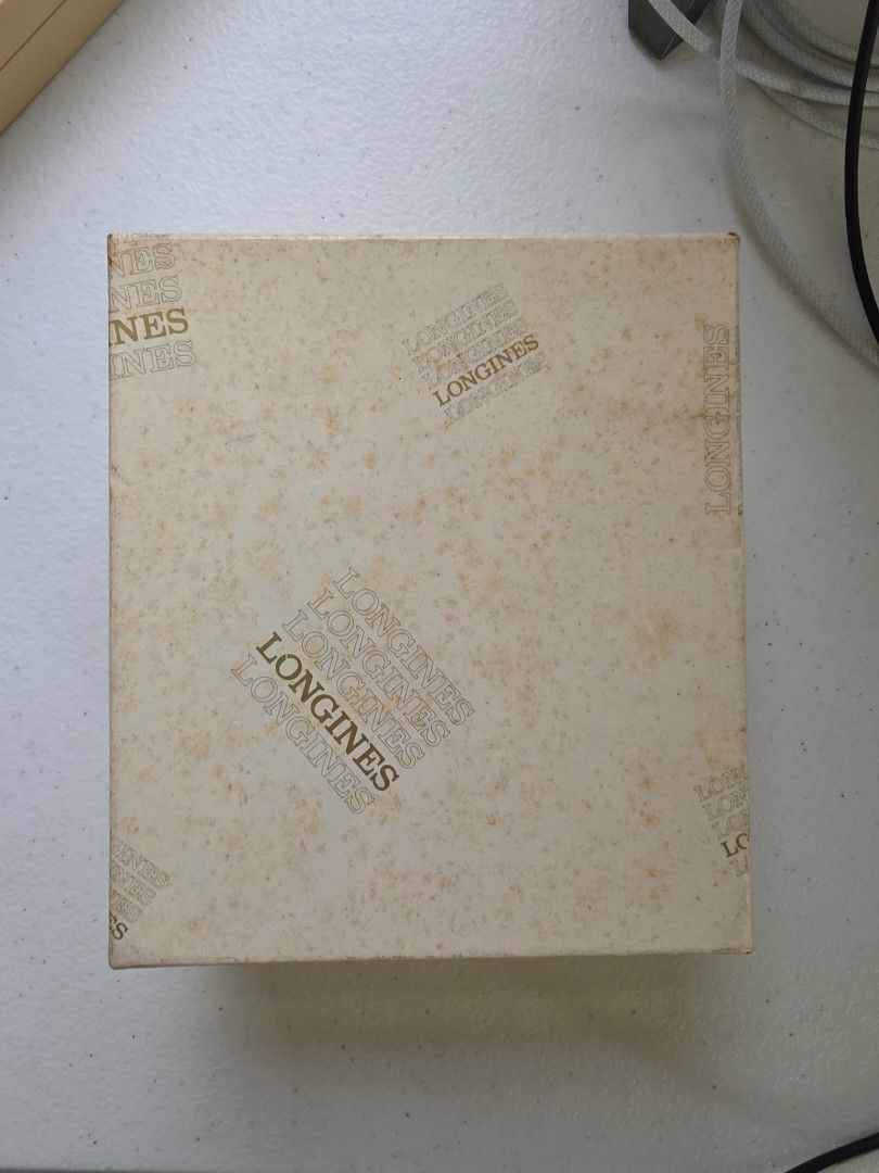 Longines Vintage Watch Presentation Box with Outer Box (Category: Luxury Watches) located in Malolos. Submitted by 888collectibles (Listing ID 1468801081, Image 3). Description: - 100% Authentic Longines watch storage box and outer packaging for 70s and 80s - Deep brown faux leather finish with elegant gold lettering and trim - Luxurious beige velvet interior lining with a removable watch pillow cushion - Includes matching outer cardboard box fea