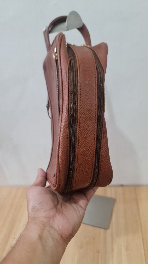 Louis Vuitton Brown Leather Pouch (Category: Luxury Bags & Wallets) located in Caloocan City. Submitted by royaldragon_d59aba (Listing ID 1468757141, Image 2). Description: - Brand: Louis Vuitton - Color/Material: Brown textured leather and coated textile - Closures: Secure double zip top closure plus an extra side zipped pocket - Handle: Small leather loop handle on the slider for easy carrying - Interior: Premium calf leather lining.