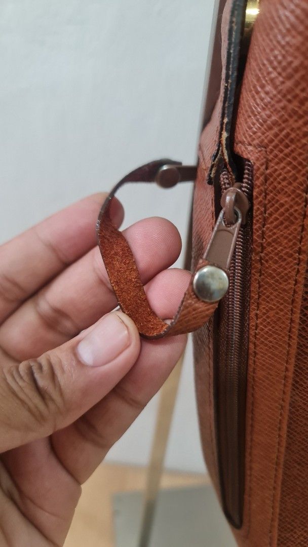 Louis Vuitton Brown Leather Pouch (Category: Luxury Bags & Wallets) located in Caloocan City. Submitted by royaldragon_d59aba (Listing ID 1468757141, Image 3). Description: - Brand: Louis Vuitton - Color/Material: Brown textured leather and coated textile - Closures: Secure double zip top closure plus an extra side zipped pocket - Handle: Small leather loop handle on the slider for easy carrying - Interior: Premium calf leather lining.