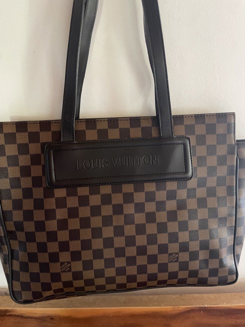 Louis Vuitton Damier Ebene Tote Bag (Category: Luxury Bags & Wallets) located in Pasuquin. Submitted by licashop.ph (Listing ID 1468731583, Image 2). Description: - Brown and black check pattern canvas tote - Structured leather handles and embossed Louis Vuitton front patch - Bright red interior lining with zipped pocket and D-ring attachment - Gold-tone hardware featuring LV logo zipper pull - Inside leather tag stamped Louis Vuitton Paris Made 