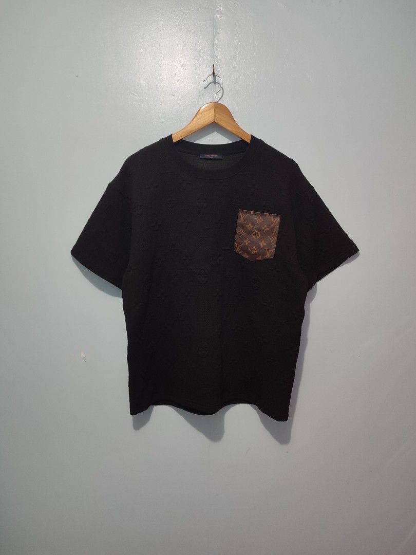 Louis Vuitton Monogram Pocket T-Shirt Black (Category: Tshirts & Polo Shirts ) located in Solana. Submitted by sonnymcamp28502 (Listing ID 1468849415, Image 2). Description: - Brand: Louis Vuitton - Color: Black with brown monogram chest pocket - Pattern: Subtle all-over embossed monogram - Size: M - Material: 100% cotton, Made in Italy - Details: Blue neck label with orange logo text - Care: Gentle dry clean only - Condition: Excellent / Well-ma