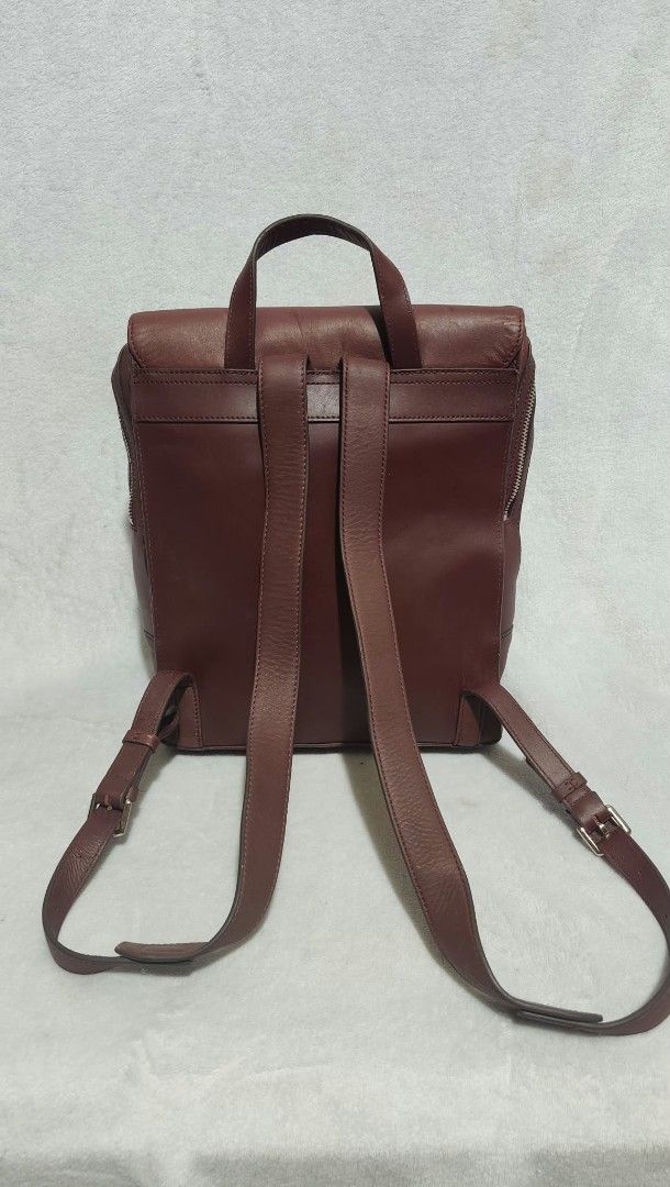 LOVCAT Leather Backpack Dark Red (Category: Backpacks) located in Bulacan. Submitted by georgiaapparel (Listing ID 1468890106, Image 3). Description: - Brand: LOVCAT - Color: Dark red - Material: Smooth leather finish - Closure: Flap front with secure snap button - Accessibility: Convenient side zipper access to the main compartment - Comfort: Adjustable shoulder straps and sturdy top handle - Condition: Excellent/Well-maintained - Best for: Dail