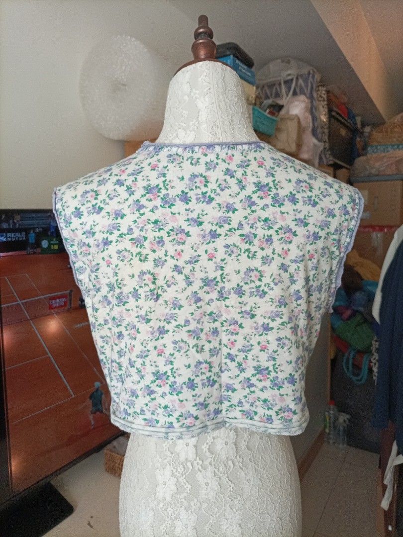 LoveShackFancy Floral Crop Top Size XS (Category: Sleeveless) located in Pasig City. Submitted by sandacecloset (Listing ID 1468788037, Image 2). Description: - Brand: LoveShackFancy - Size: XS - Material: 100% Cotton - Design: Pink, purple, and green floral print on off-white background - Details: Contrast purple whipstitching on neckline/arms, raw edge hem, sleeveless - Care: Hand wash cold - Condition: there are several small holes on the shir