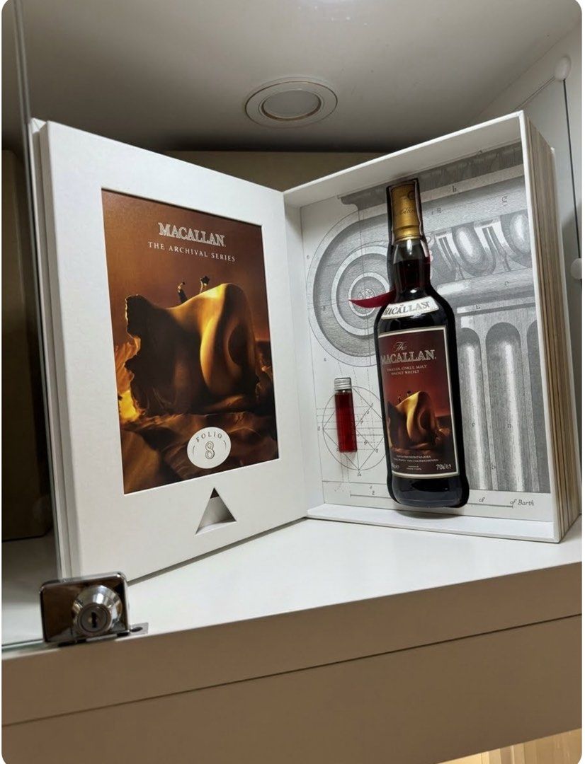 Macallan collectible (Category: Other Food & Drinks) located in Quezon City. Submitted by shopwitease (Listing ID 1468755266, Image 1). Description: • A premium white, book-shaped presentation box is open on a shelf. The left side features a surrealist, warm-toned art piece labeled “Folio 8”. The right side safely holds a bottle of dark amber Macallan single malt scotch whisky against a black-and-white architectural sketch backdrop. .