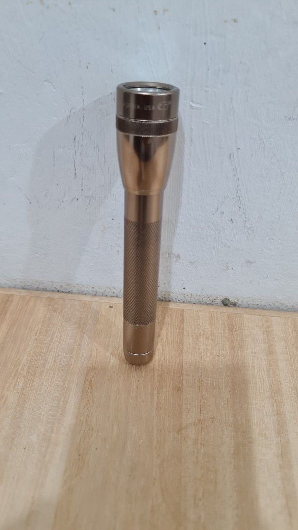 Maglite Solitaire Mini Flashlight (Category: Lighting) located in Caloocan City. Submitted by royaldragon_d59aba (Listing ID 1468875870, Image 1). Description: - Color: Elegant gold tone - Material: Durable compact metal - Grip: Knurled barrel for a secure hold - Mechanism: Twist head for on/off and beam focus - Portability: Integrated keyring attachment on tail cap - Power: Uses standard small batteries - Size: Pocket-friendly and easy to carry.