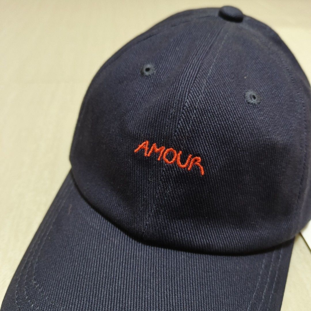Maison Labiche Beaumont Amour Cap Carbon Blue (Category: Caps & Hats) located in Nasugbu. Submitted by staffpicks1515 (Listing ID 1468794682, Image 3). Description: - Brand: Maison Labiche - Color: Carbon blue with red 'AMOUR' embroidery - Material: 100% cotton - Size: Adjustable back strap with metal buckle - Condition: Brand new with original hangtags attached, never worn.