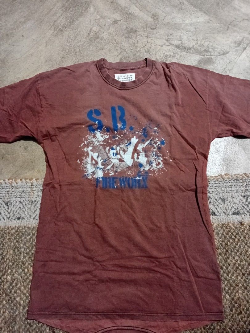 Maison Margiela Artisanal Reconstructed Tee (Category: Tshirts & Polo Shirts ) located in Makati City. Submitted by homme.boy.plus (Listing ID 1468832908, Image 2). Description: Maison Margiela SS13 Reddish brown with vintage wash reconstructed tee Large blue patterned square patch on the back, iconic four white stitches on upper back, and number tag with circled '10' inside collar Short sleeves, crew neck Excellent 21x28 .