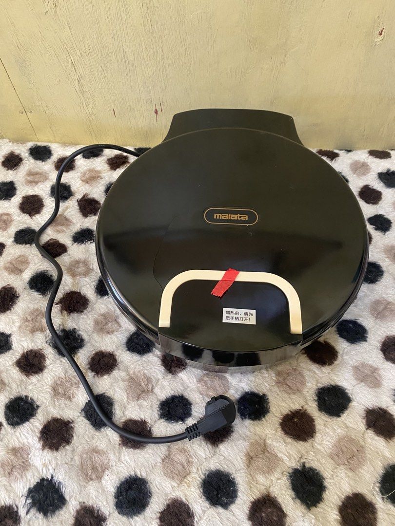 Malata Electric Baking Pan Non-Stick Griddle (Category: Cookware & Accessories) located in Baguio. Submitted by thrift_bonita (Listing ID 1468726081, Image 1). Description: - Brand: Malata - Color: Black with non-stick speckled cooking surface - Features: Dual power switches with indicator lights and built-in cooking time guide - Condition: Powers on and heats up normally, but has a noticeable crack on the top lid housing near the handle - Ideal 