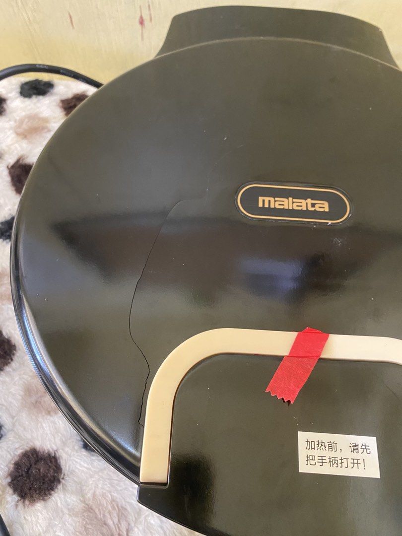 Malata Electric Baking Pan Non-Stick Griddle (Category: Cookware & Accessories) located in Baguio. Submitted by thrift_bonita (Listing ID 1468726081, Image 2). Description: - Brand: Malata - Color: Black with non-stick speckled cooking surface - Features: Dual power switches with indicator lights and built-in cooking time guide - Condition: Powers on and heats up normally, but has a noticeable crack on the top lid housing near the handle - Ideal 