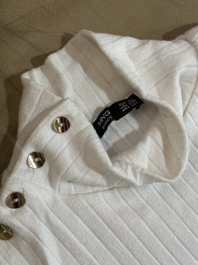Mango Basics White Turtleneck Sweater XS (Category: Longsleeves) located in Davao. Submitted by mommyye (Listing ID 1468763689, Image 2). Description: - Brand: MNG Basics - Color: White - Size: EUR XS / USA XXS - Material: Soft knit fabric - Design: Ribbed turtleneck, fitted cut, long sleeves - Detail: Decorative silver-tone buttons on left shoulder and collar.
