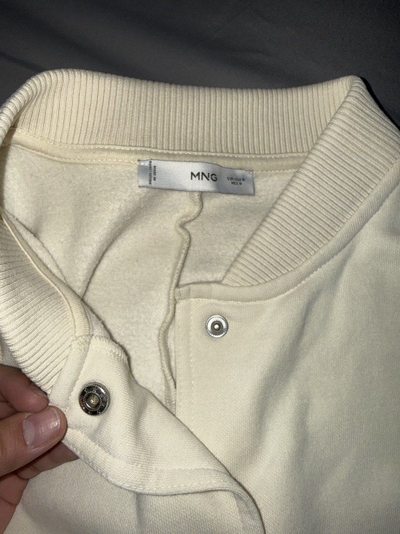 MANGO (MNG) CREAM CROPPED BOMBER JACKET (Category: Coats, Jackets and Outerwear) located in Las Pinas. Submitted by coolthreadz (Listing ID 1468825111, Image 3). Description: 🤍 MANGO (MNG) CREAM CROPPED BOMBER JACKET 🏷️ Brand: Mango (MNG) 📏 Size: Medium (M) 🎨 Color: Cream / Off-White ✨ Condition: Preloved * Stylish cropped bomber jacket with snap-button closure. * Features two front flap pockets and ribbed collar, cuffs, and hem. * Soft, cozy