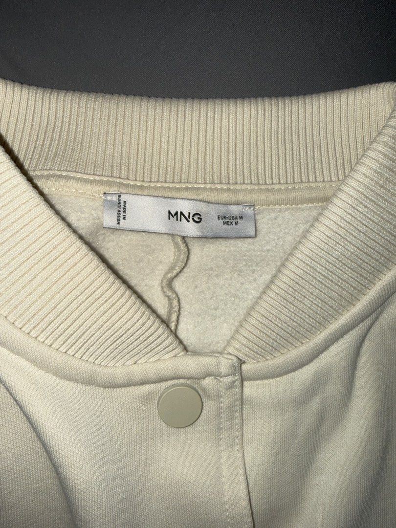 MANGO (MNG) CREAM CROPPED BOMBER JACKET (Category: Coats, Jackets and Outerwear) located in Las Pinas. Submitted by coolthreadz (Listing ID 1468825111, Image 2). Description: 🤍 MANGO (MNG) CREAM CROPPED BOMBER JACKET 🏷️ Brand: Mango (MNG) 📏 Size: Medium (M) 🎨 Color: Cream / Off-White ✨ Condition: Preloved * Stylish cropped bomber jacket with snap-button closure. * Features two front flap pockets and ribbed collar, cuffs, and hem. * Soft, cozy
