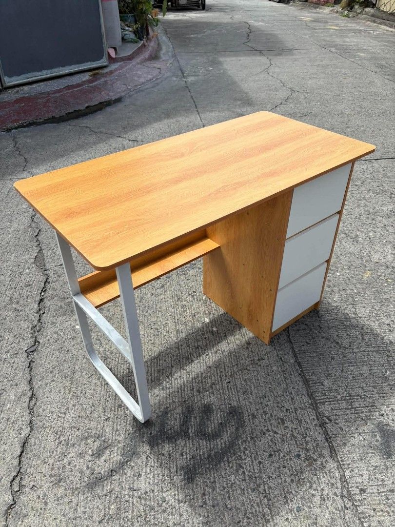 Maple Cherry Wood Study Desk with 3 Drawers (Category: Tables & Sets) located in Manila. Submitted by ajimdolor012051 (Listing ID 1468769764, Image 3). Description: - Dimensions: 100cm (L) x 50cm (W) x 74.5cm (H) - Material: Clean maple cherry wood finish with a sturdy white metal frame - Storage: 3 convenient white drawers on the right and an open shelf under the tabletop - Workspace: Spacious surface ideal for laptops, monitors, and books - Con