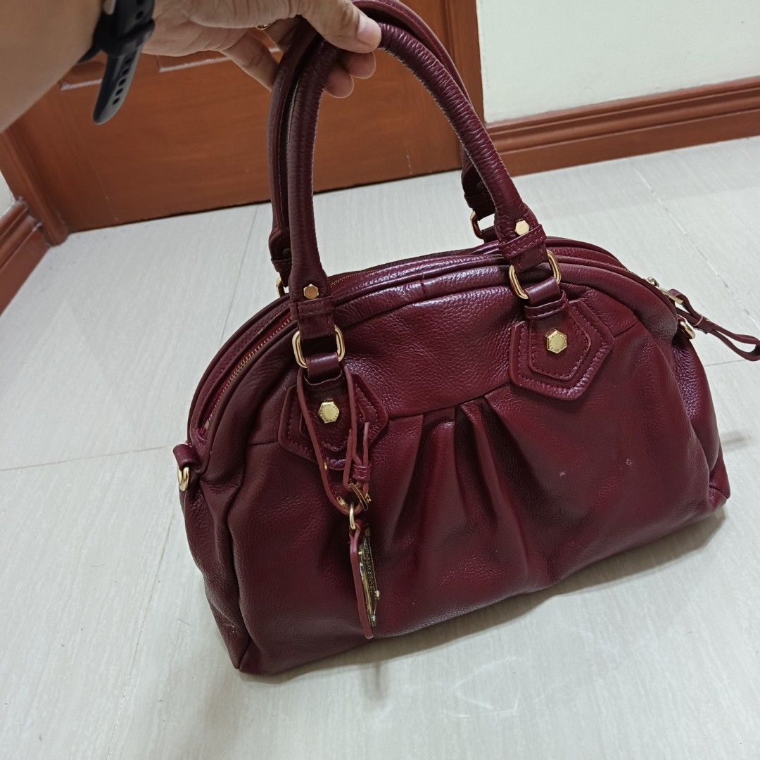 Marc by Marc Jacobs Leather Two Way Shoulder Bag (Category: Luxury Bags & Wallets) located in Nasugbu. Submitted by staffpicks1515 (Listing ID 1468788875, Image 3). Description: - Brand: Marc by Marc Jacobs - Material: Genuine burgundy leather with gold-tone hardware - Design: Gathered details with iconic Standard Supply metal plaque - Closure & Interior: Top zip closure, printed fabric lining, and inner zipper pocket - Handles: Dual top handles 
