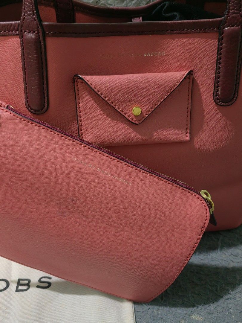 Marc by Marc Jacobs Pink Leather Tote Bag (Category: Tote Bags) located in Las Pinas. Submitted by huslerz (Listing ID 1468818823, Image 2). Description: - Brand: Marc Jacobs - Style: Leather Tote Bag - Color: Pink with dark maroon straps and trim - Hardware: Gold tone details - Inclusions: Matching zip pouch and original dust bag - Features: Small front envelope pocket for easy access - Condition: Well-maintained and ready to use - Meet-ups and 