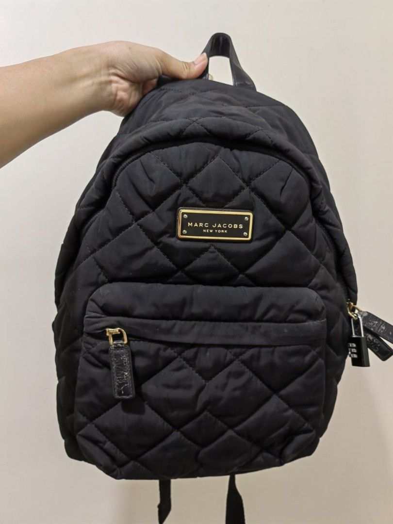 MARC JACOBS BLACK QUILTED NYLON BACKPACK (authentic) (Category: Luxury Bags & Wallets) located in Quezon City. Submitted by hirayacisum (Listing ID 1468748142, Image 1). Description: Material: Lightweight quilted nylon paired with leather zipper pulls and trim. Design: Classic dual-compartment layout including a roomy main body and a prominent zippered front pocket. Hardware: Polished gold-toned plaque stamped with "Marc Jacobs New York"..