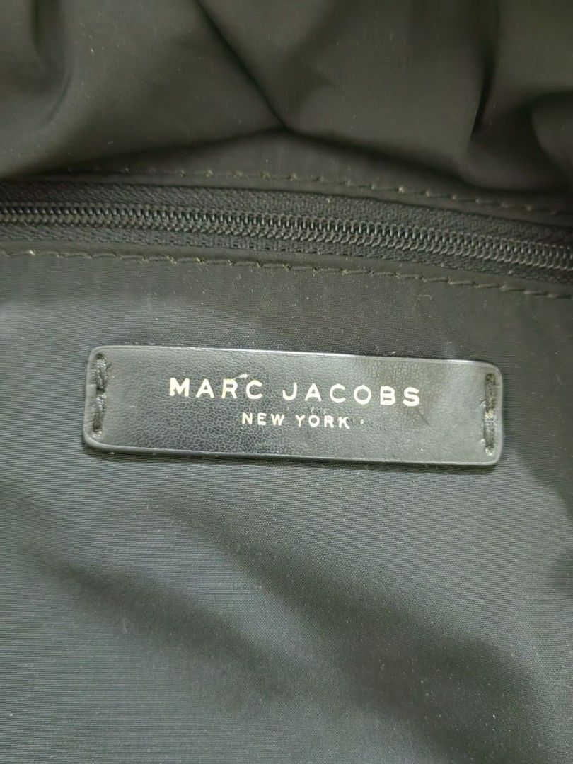 MARC JACOBS BLACK QUILTED NYLON BACKPACK (authentic) (Category: Luxury Bags & Wallets) located in Quezon City. Submitted by hirayacisum (Listing ID 1468748142, Image 3). Description: Material: Lightweight quilted nylon paired with leather zipper pulls and trim. Design: Classic dual-compartment layout including a roomy main body and a prominent zippered front pocket. Hardware: Polished gold-toned plaque stamped with "Marc Jacobs New York"..