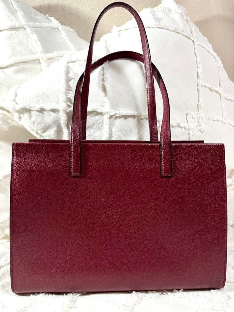 Marc Jacobs Burgundy Tote Bag (Category: Tote Bags) located in Bulacan. Submitted by vintage_purge (Listing ID 1468795276, Image 3). Description: - Authentic Marc Jacobs New York tote bag in rich burgundy leather - Structured design with dual top handles and gold-tone hardware - Front exterior slip pocket with a cute padlock accent - Secure zip-top closure to keep your belongings safe - Spacious interior easily fits a laptop, school books, and da