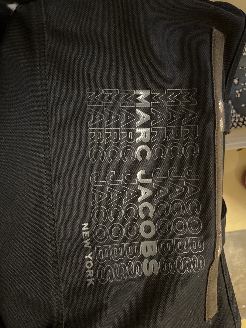 Marc Jacobs New York Canvas Tote Bag (Category: Tote Bags) located in Manila. Submitted by rogerfranklin (Listing ID 1468713466, Image 1). Description: - Brand: Marc Jacobs New York - Color: Black with bold graphic logo print - Material: Durable canvas fabric - Design: Contrasting side stripe detail - Condition: Clean interior, sturdy handles - Usage: Spacious daily carryall for work, school, or casual lakad.