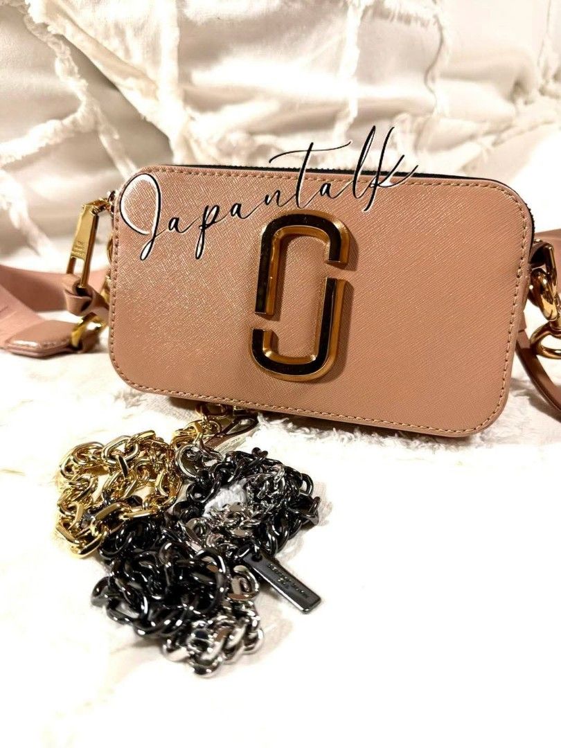 Marc Jacobs Snapshot Camera Bag Pink (Category: Luxury Bags & Wallets) located in Bulacan. Submitted by vintage_purge (Listing ID 1468797541, Image 2). Description: - Brand: Marc Jacobs Snapshot Bag - Color: Dusty Pink with Gold-tone hardware - Material: Durable Saffiano leather - Design: Iconic double-J logo, dual zip compartments, and back slip pocket - Straps included: 1x branded wide fabric strap AND 2x bonus interchangeable chains (gold and 