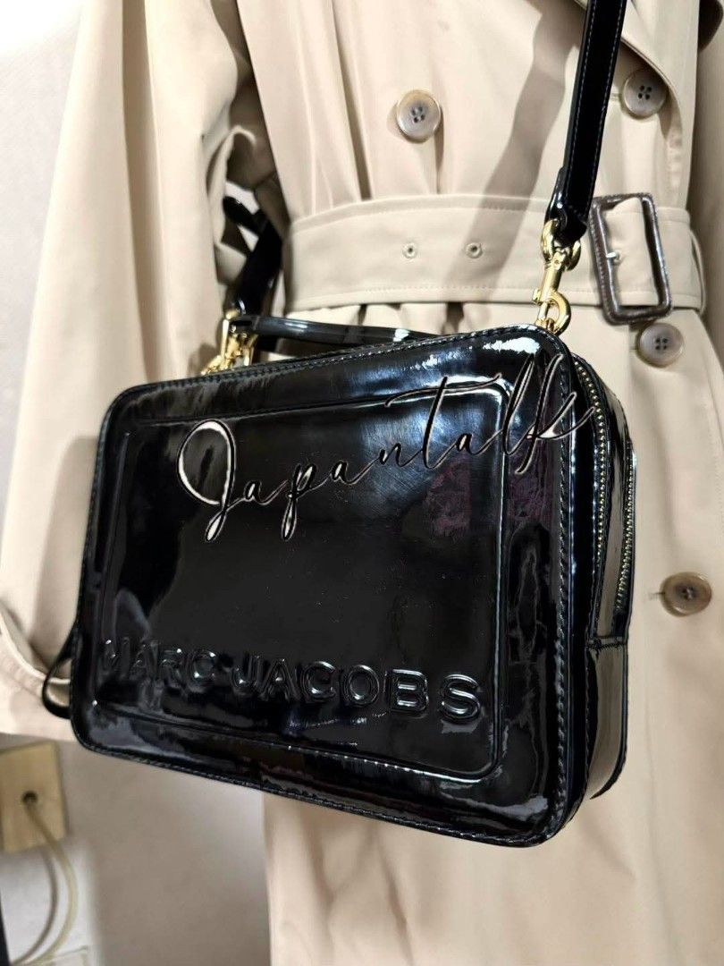 Marc Jacobs Vanity Bag Patent Black (Category: Luxury Bags & Wallets) located in Bulacan. Submitted by vintage_purge (Listing ID 1468796222, Image 3). Description: - Brand: Marc Jacobs - Material: Glossy black patent leather - Design: Structured box shape with embossed branding and gold-tone hardware - Closure: Dual top zippers - Straps: Short top handle and detachable shoulder strap - Inclusions: Complete with tags, care card, and original dust 
