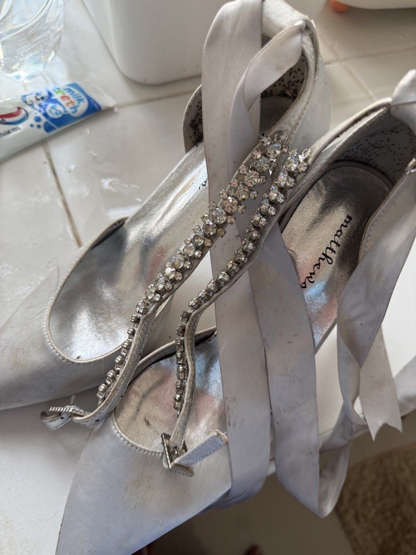 Matthews Silver Rhinestone Strappy Heels (Category: Heels) located in Manila. Submitted by maia_zsa (Listing ID 1468738294, Image 2). Description: - Brand: Matthews - Color: Silver - Style: Heels with rhinestone front strap and ribbon ankle ties - Flaws: Visible scuff marks and dirt on the satin fabric and insoles - Additional Notes: Interior heel lining has dark spots and staining - Perfect for budget-friendly glam nights!.