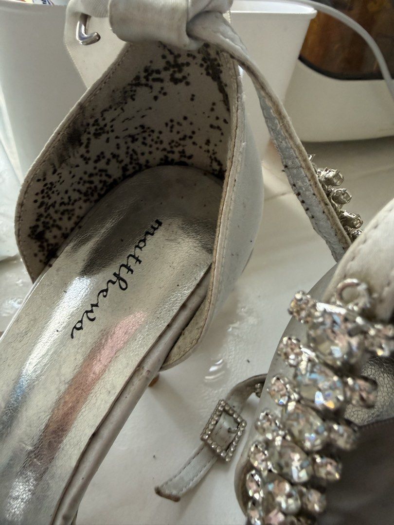 Matthews Silver Rhinestone Strappy Heels (Category: Heels) located in Manila. Submitted by maia_zsa (Listing ID 1468738294, Image 3). Description: - Brand: Matthews - Color: Silver - Style: Heels with rhinestone front strap and ribbon ankle ties - Flaws: Visible scuff marks and dirt on the satin fabric and insoles - Additional Notes: Interior heel lining has dark spots and staining - Perfect for budget-friendly glam nights!.