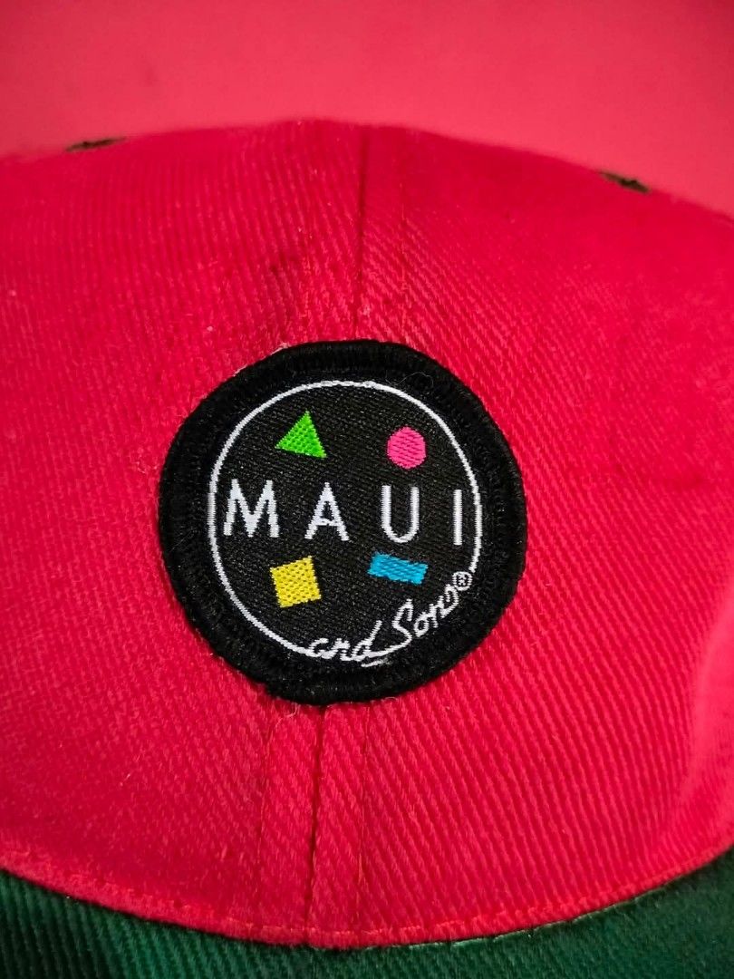 Maui and Sons Snapback Hat Red Green (Category: Caps & Hats) located in Mangaldan. Submitted by niftythrifty69 (Listing ID 1468734375, Image 2). Description: - Brand: Maui and Sons - Design: Round embroidered patch logo with colorful geometric shapes on the front - Colors: Vibrant red body with a contrast green flat brim - Fit: Adjustable snapback closure for a customized fit - Details: Interior features branded black taping and official tags - C