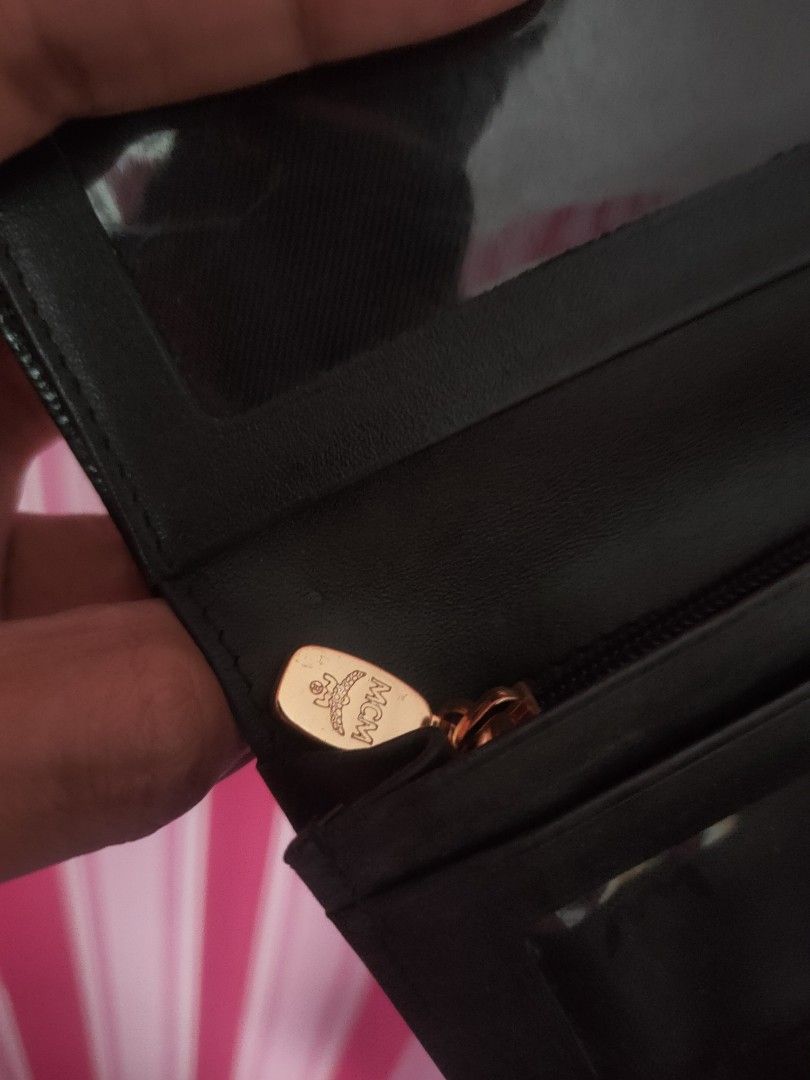 MCM Black Leather Trifold Wallet with Gold Hardware (Category: Luxury Bags & Wallets) located in Urdaneta. Submitted by assortedprelovedd (Listing ID 1468765324, Image 3). Description: - Brand: MCM - Material: Premium black textured leather - Hardware: Elegant gold-toned accents - Closure: Secure snap button - Interior: Clean lining with MCM stamped logo - Compartments: Multiple card slots, ID window pockets, and a full-length cash compartment - 