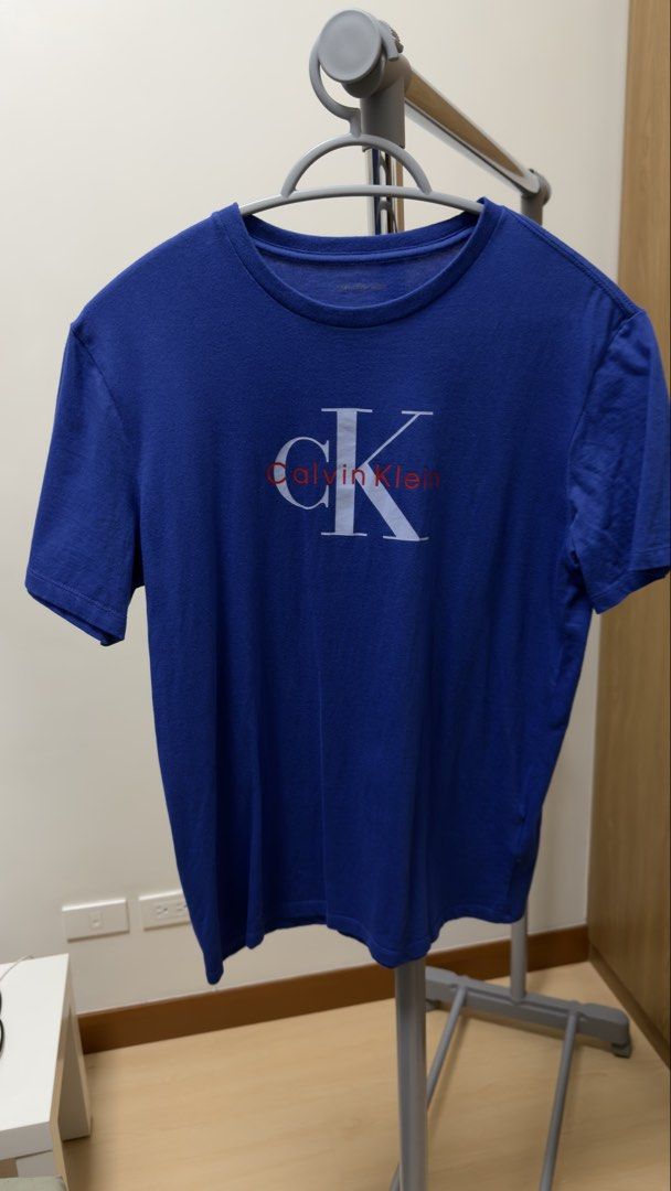[Men]Calvin Klein T-Shirt (Category: Tshirts & Polo Shirts ) located in Manila. Submitted by rare_closetcleanout (Listing ID 1468803871, Image 1). Description: - Brand: Calvin Klein Jeans - Color: Blue with white and red chest logo - Size: XS - Material: Comfortable, breathable cotton - Design: Crew neck with tagless printed collar - Condition: Great shape, well-maintained and ready to wear - Style: Versatile and easy to match with daily casual o