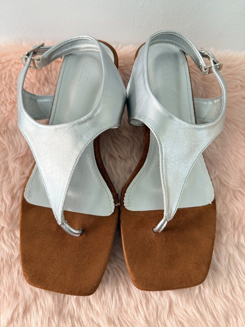 Metallic silver thong wedge sandals square toe size 38 (Category: Flats & Sandals) located in Quezon City. Submitted by shaberbree (Listing ID 1468737398, Image 1). Description: - Color: Metallic silver and brown - Design: Stylish square toe with a comfortable wedge heel - Fit: Adjustable slingback strap with a secure silver buckle closure - Size: Stamped size 38 on the bottom sole - Condition: Clean footbeds and outsoles, well-maintained.