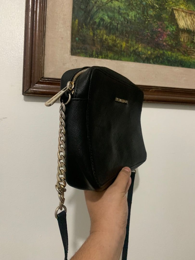 Michael Kors Black Crossbody Bag (Category: Cross-body Bags) located in Lapu Lapu. Submitted by goodfindsbyshee (Listing ID 1468925980, Image 2). Description: - Brand: Michael Kors - Material: Genuine black leather - Hardware: Premium gold-tone - Closure: Secure zip-top - Strap: Elegant chain accent - Interior: Fabric-lined with 1 slip pocket - Shape: Trendy and structured camera bag - Condition: Excellent, clean inside and out.