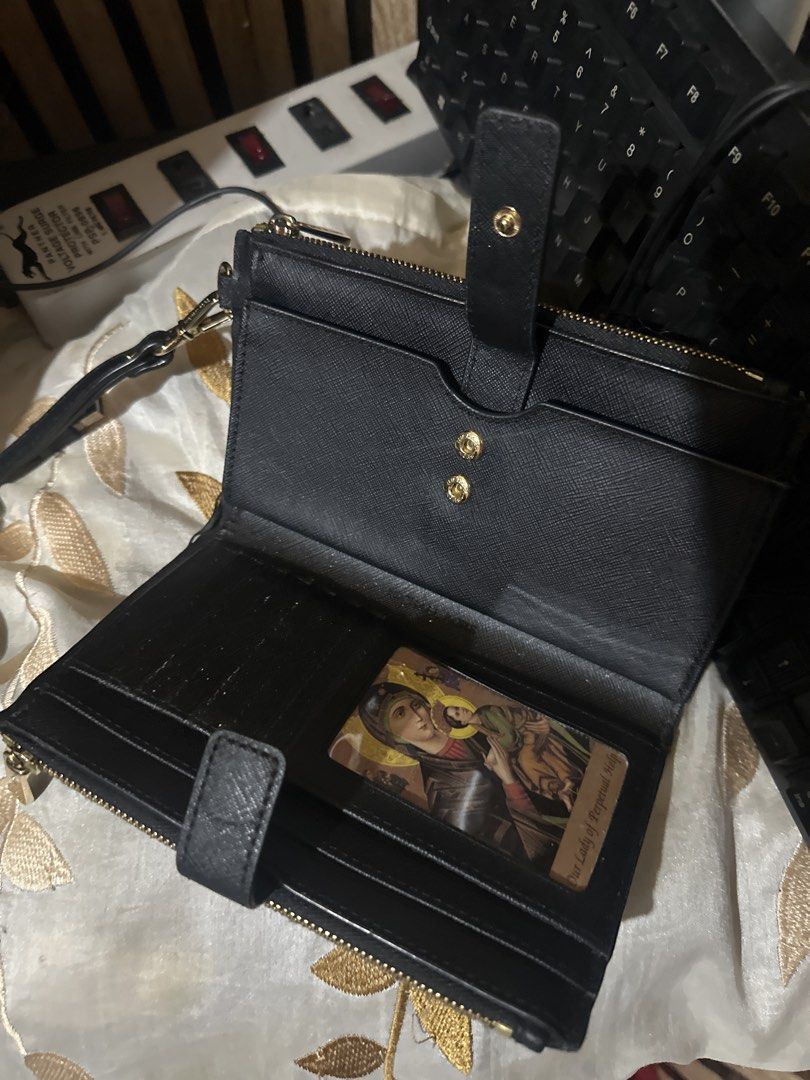 Michael Kors Black Monogram Double Zip Wallet Wristlet (Category: Wallets & Card holders) located in Manila. Submitted by chinitangtisay (Listing ID 1468880849, Image 2). Description: - Brand: Michael Kors - Color: Classic Black with Monogram design - Material: Durable Saffiano leather texture - Hardware: Elegant gold-tone hardware and MK lettering - Compartments: Convenient double zip compartments on top - Closure: Snap tab closure for the main 