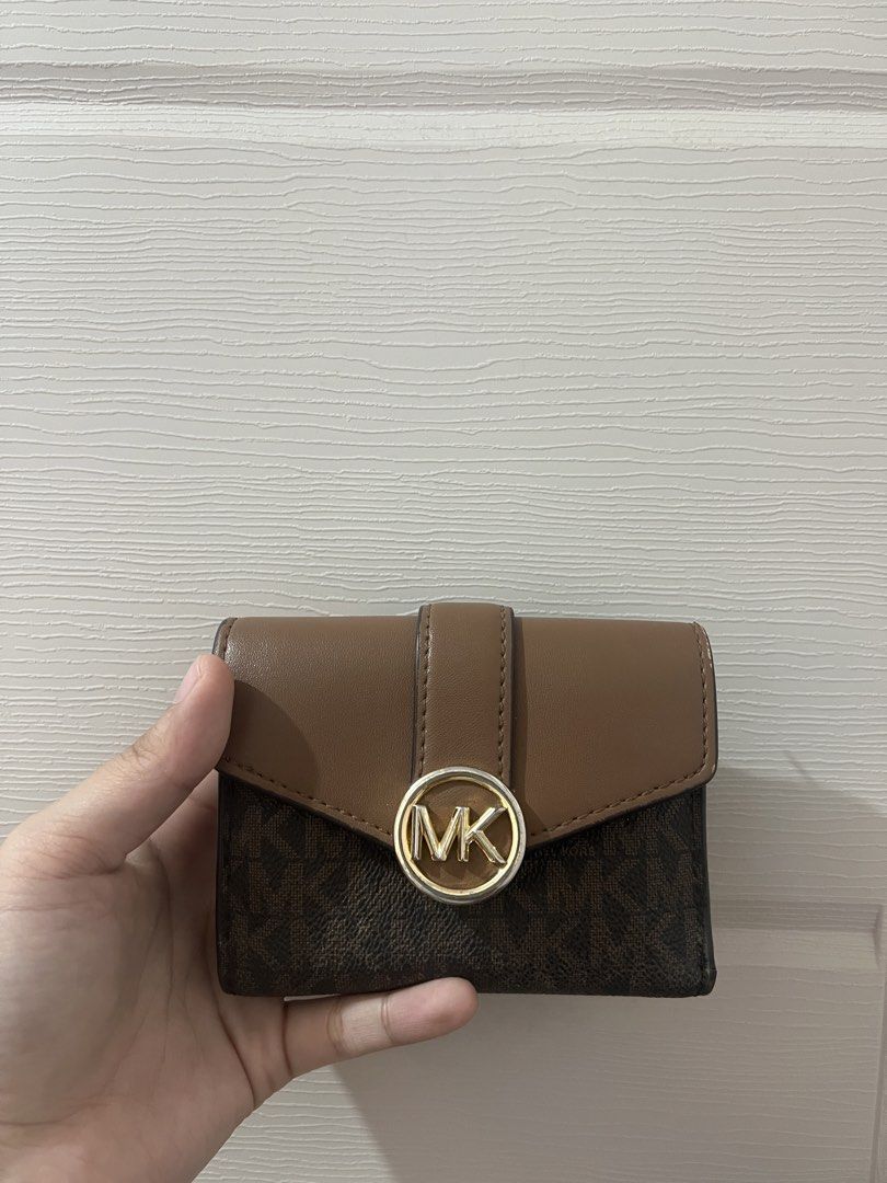 Michael Kors Brown Monogram Bi-fold Wallet (Category: Luxury Bags & Wallets) located in Santa Cruz. Submitted by alliyah. (Listing ID 1468713352, Image 1). Description: Bought this around 3.8k Selling for only 1.8k - Brand: Michael Kors - Style: Bi-fold wallet - Design: Signature monogram print with solid brown leather flap and gold-tone MK circle hardware - Features: Multiple card slots and a secure zippered pocket inside - Size: Compact, fits e