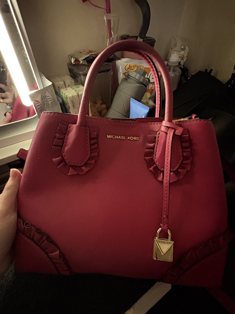 Michael Kors Mercer Gallery (Category: Luxury Bags & Wallets) located in Baguio. Submitted by aella_nyx (Listing ID 1468759800, Image 1). Description: The Michael Kors Mercer Gallery bag features a vibrant fuchsia pink color, structured silhouette, double top handles, and decorative ruffle details on the front and bottom corners. It also comes with a detachable shoulder strap for versatile carrying options. The bag is in heavily used condition, s