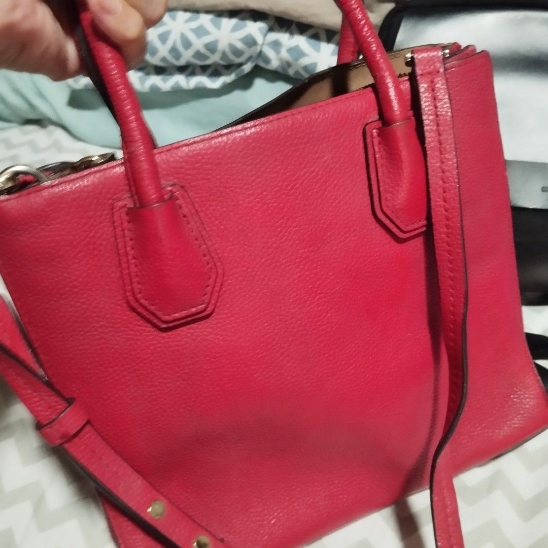 Michael Kors Red Leather Tote Handbag (Category: Tote Bags) located in Manila. Submitted by lene48 (Listing ID 1468837968, Image 1). Description: - Brand: Michael Kors - Material: Bright red pebble leather - Hardware: Gold-tone with protective metal feet on the bottom - Straps: Dual top handles and a removable shoulder strap - Interior: Includes zip and slip pockets - Condition: Clean inside and out, with minor wear on the handles.