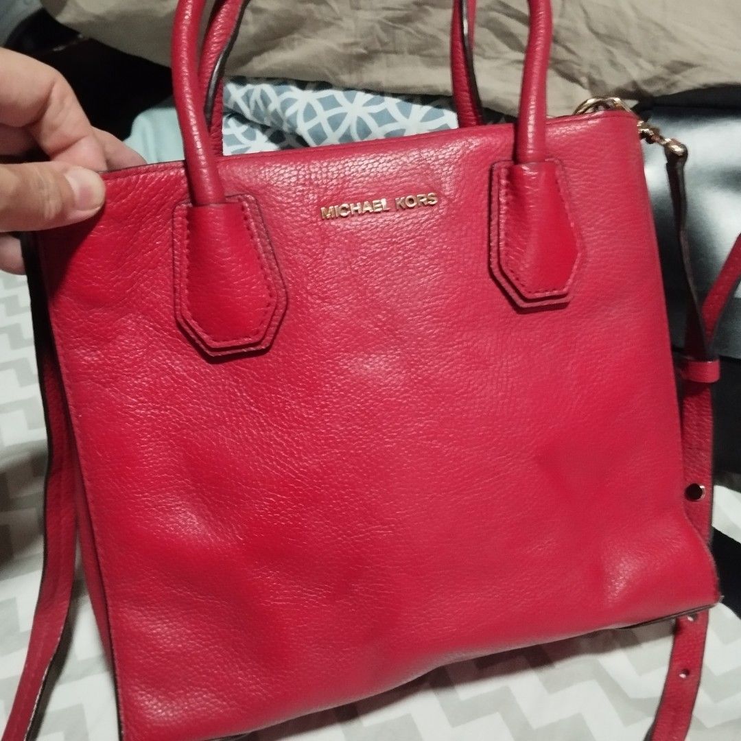 Michael Kors Red Leather Tote Handbag (Category: Tote Bags) located in Manila. Submitted by lene48 (Listing ID 1468837968, Image 2). Description: - Brand: Michael Kors - Material: Bright red pebble leather - Hardware: Gold-tone with protective metal feet on the bottom - Straps: Dual top handles and a removable shoulder strap - Interior: Includes zip and slip pockets - Condition: Clean inside and out, with minor wear on the handles.