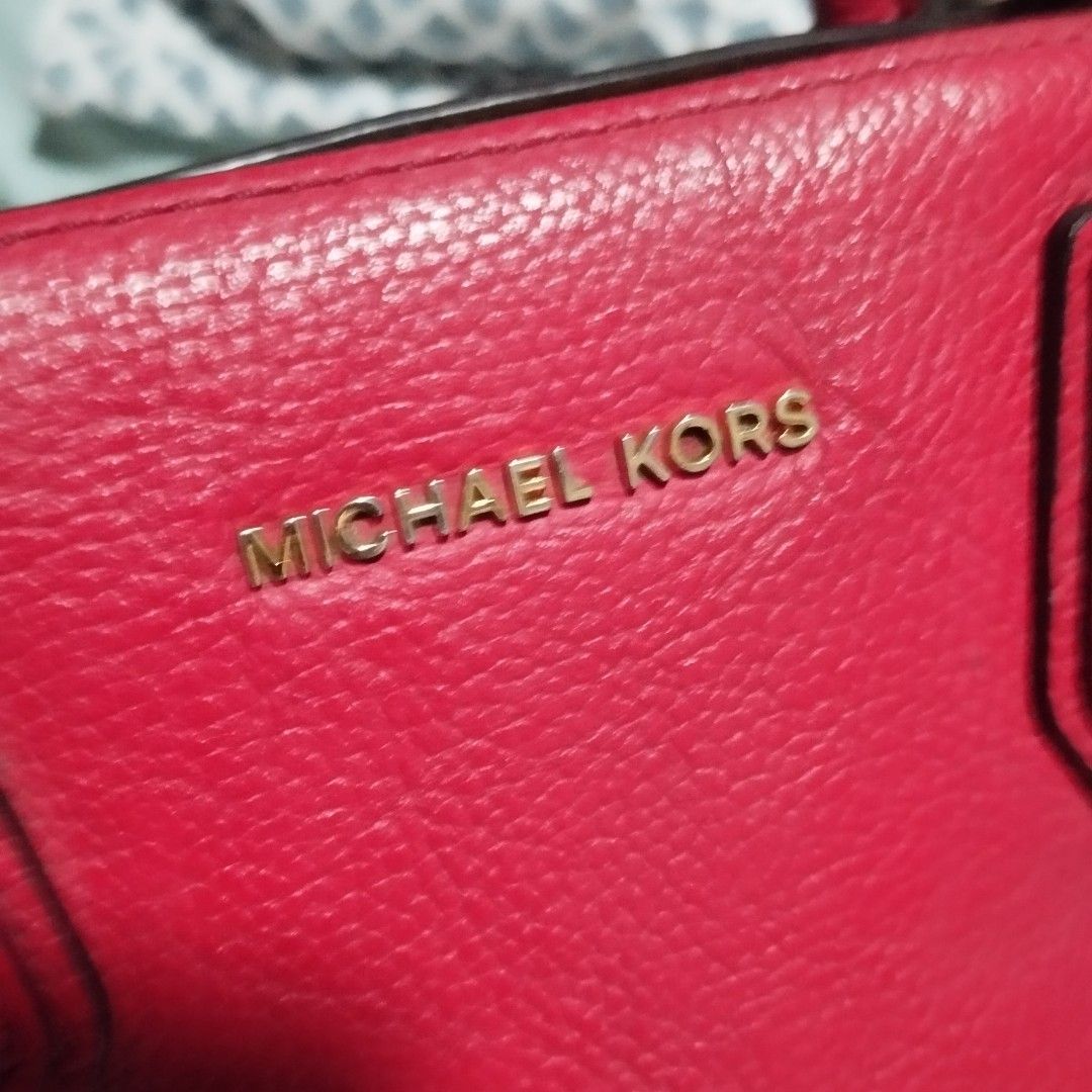 Michael Kors Red Leather Tote Handbag (Category: Tote Bags) located in Manila. Submitted by lene48 (Listing ID 1468837968, Image 3). Description: - Brand: Michael Kors - Material: Bright red pebble leather - Hardware: Gold-tone with protective metal feet on the bottom - Straps: Dual top handles and a removable shoulder strap - Interior: Includes zip and slip pockets - Condition: Clean inside and out, with minor wear on the handles.