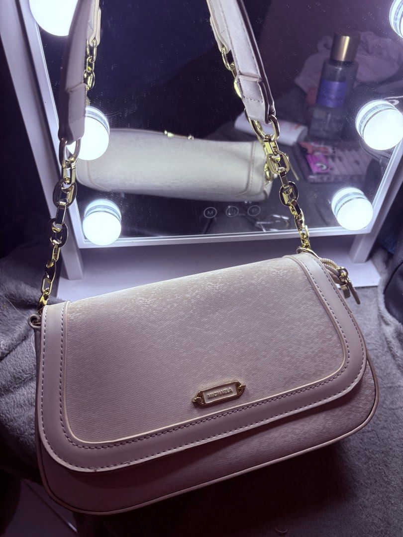 MICHAELA beige textured shoulder bag with gold chain (Category: Shoulder Bags) located in Manila. Submitted by rexibuys (Listing ID 1468881473, Image 3). Description: - Brand: MICHAELA - Color: Classic Beige - Material: Textured faux leather with gold-tone hardware - Closure: Flap with magnetic snap buttons - Interior: Zipped compartments for easy organization - Strap: Chunky chain strap with a comfortable leather shoulder rest (comes with sling 