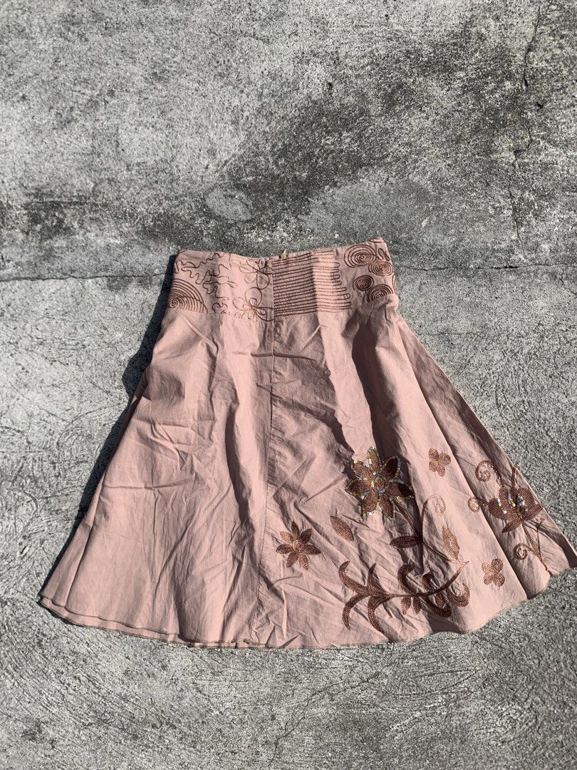 midi skirt with embroidery (Category: Skirts) located in Muntinlupa City. Submitted by pink.poppies (Listing ID 1468774818, Image 2). Description: - Color/Design: Pink midi skirt with intricate brown floral embroidery along the hem - Waistband: Wide, detailed waistband with a mid-rise fit - Special Details: Subtle silver sequins on the main flower motifs - Fit/Material: Lightweight fabric with a flattering flared silhouette - Condition: Excellent