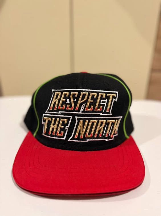 Mitchell & Ness Respect The North Snapback Cap (Category: Vintage Collectibles) located in Cebu City. Submitted by ubecstoned (Listing ID 1468825266, Image 1). Description: - Brand: Mitchell & Ness - Style: Snapback hat with flat brim - Colors: Black crown, red flat brim, and neon green piping - Embroidery: "Respect The North" in gold and white with red outlines on the front - Closure: Adjustable snapback - Authenticity: Official branding tag sti